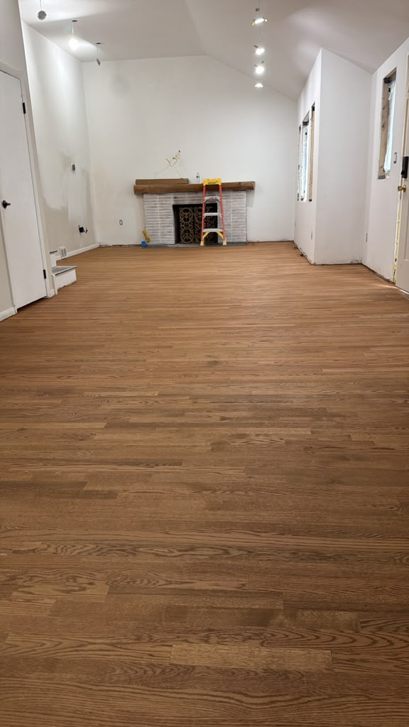 Wood flooring in a room with a fireplace during renovation